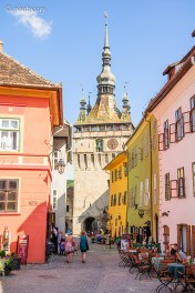 Coloured houses, cobbled street and the Clock Tower in the back