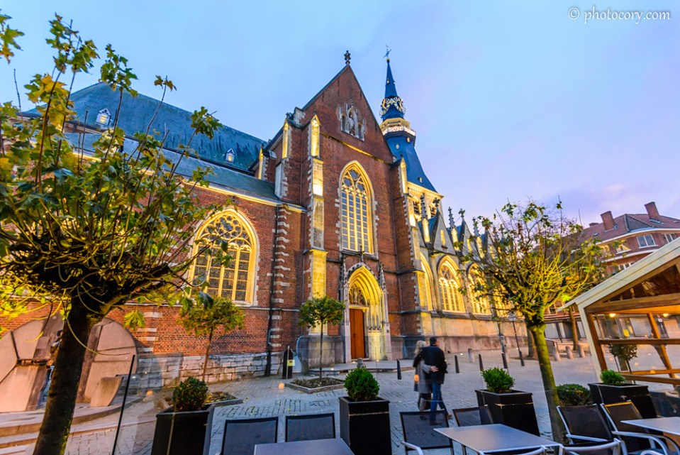 Evening blue sky with a shade of pink, the yellow lights and red bricks of the cathedral and the green leaves of the trees create a magical atmosphere