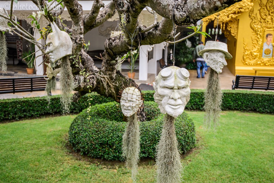 Ghost heads hanging from the trees in the garden of the White Temple