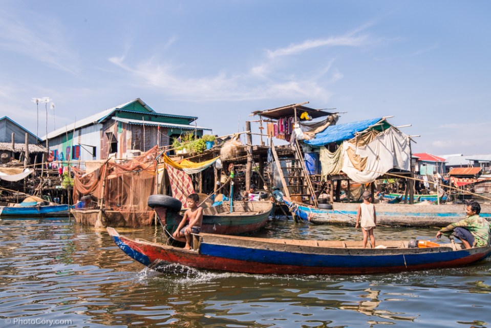 children and father on boat floating village